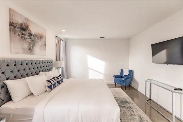 a bedroom with a bed and a flat screen tv