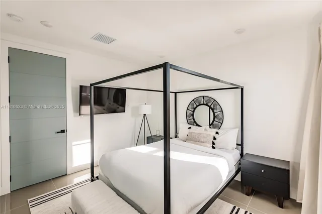 a bedroom with a bed and a large mirror