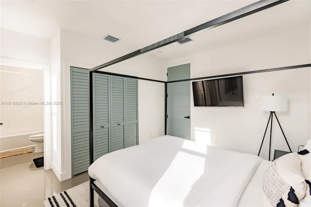 a bedroom with a bed and a flat screen tv