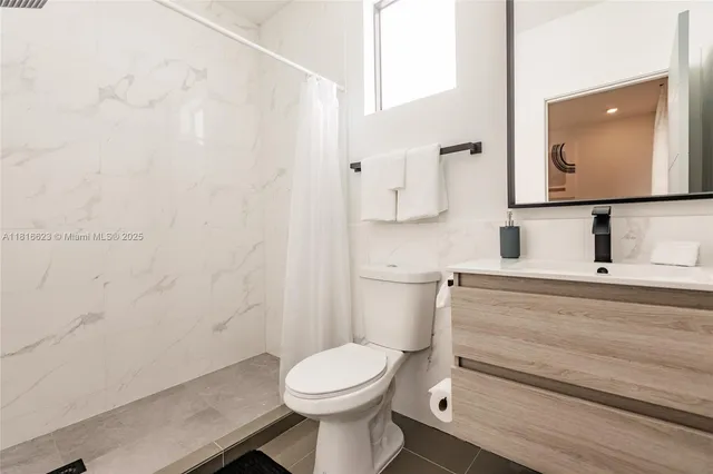 a bathroom with a toilet a sink and mirror