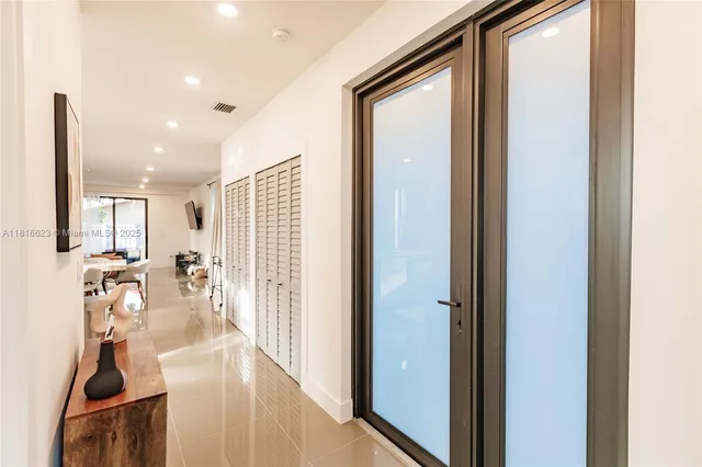 a view of a hallway with furniture and floor to ceiling window