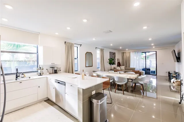a large white kitchen with a large island in the center