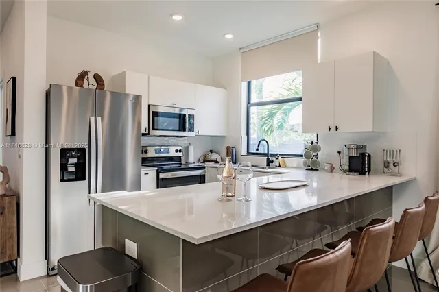a kitchen with a sink a kitchen island and stainless steel appliances