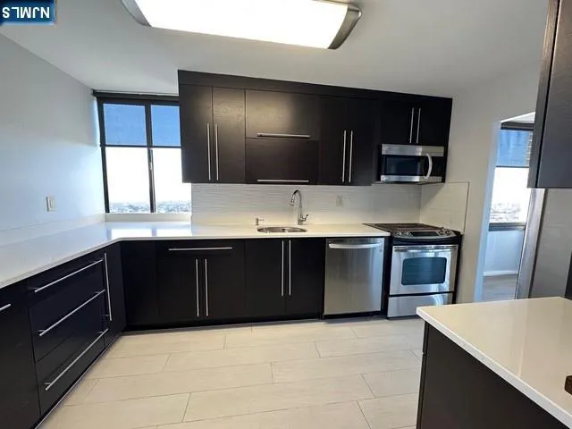 a kitchen with a refrigerator and a stove top oven