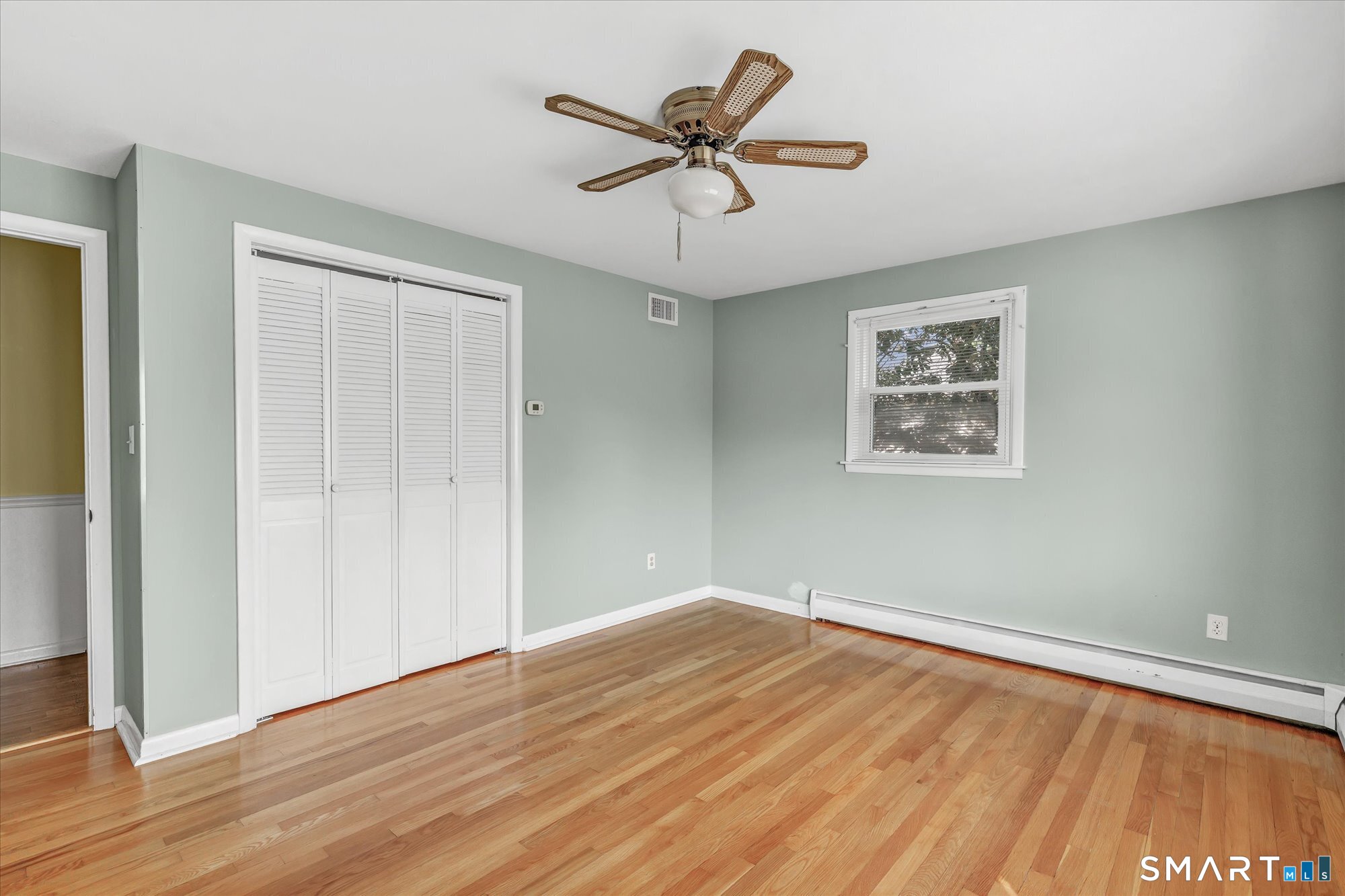 94 Ascolese Road Trumbull, CT 06611 - Photo 22 of 34 Main level bedroom with plenty of closet space and natural light and hardwood floor.