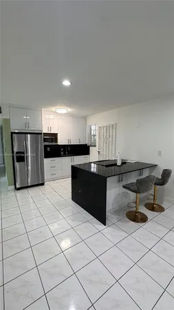 a kitchen with stainless steel appliances kitchen island granite countertop a refrigerator a stove a sink and a microwave