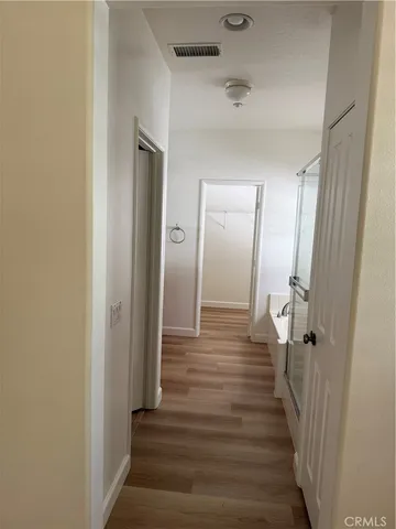 a view of a hallway with wooden floor and entryway