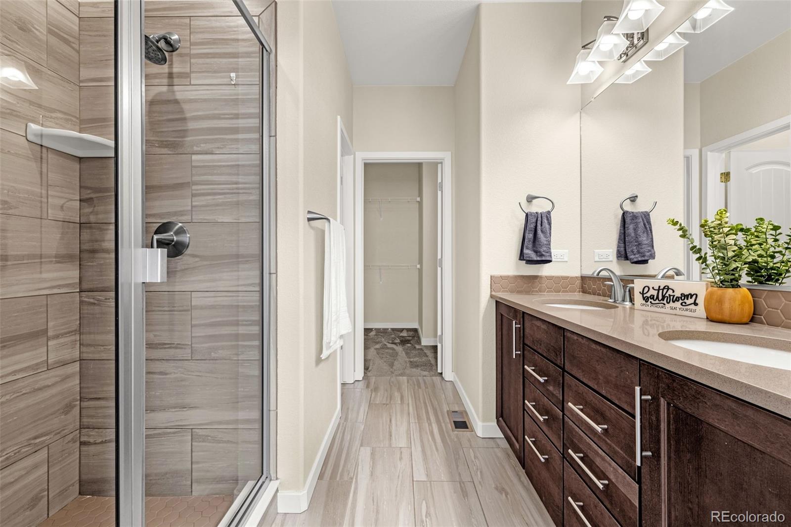 2052 Ruffino Drive Colorado Springs, CO 80921 - Photo 14 of 36 a spacious bathroom with a granite countertop sink a mirror and a shower
