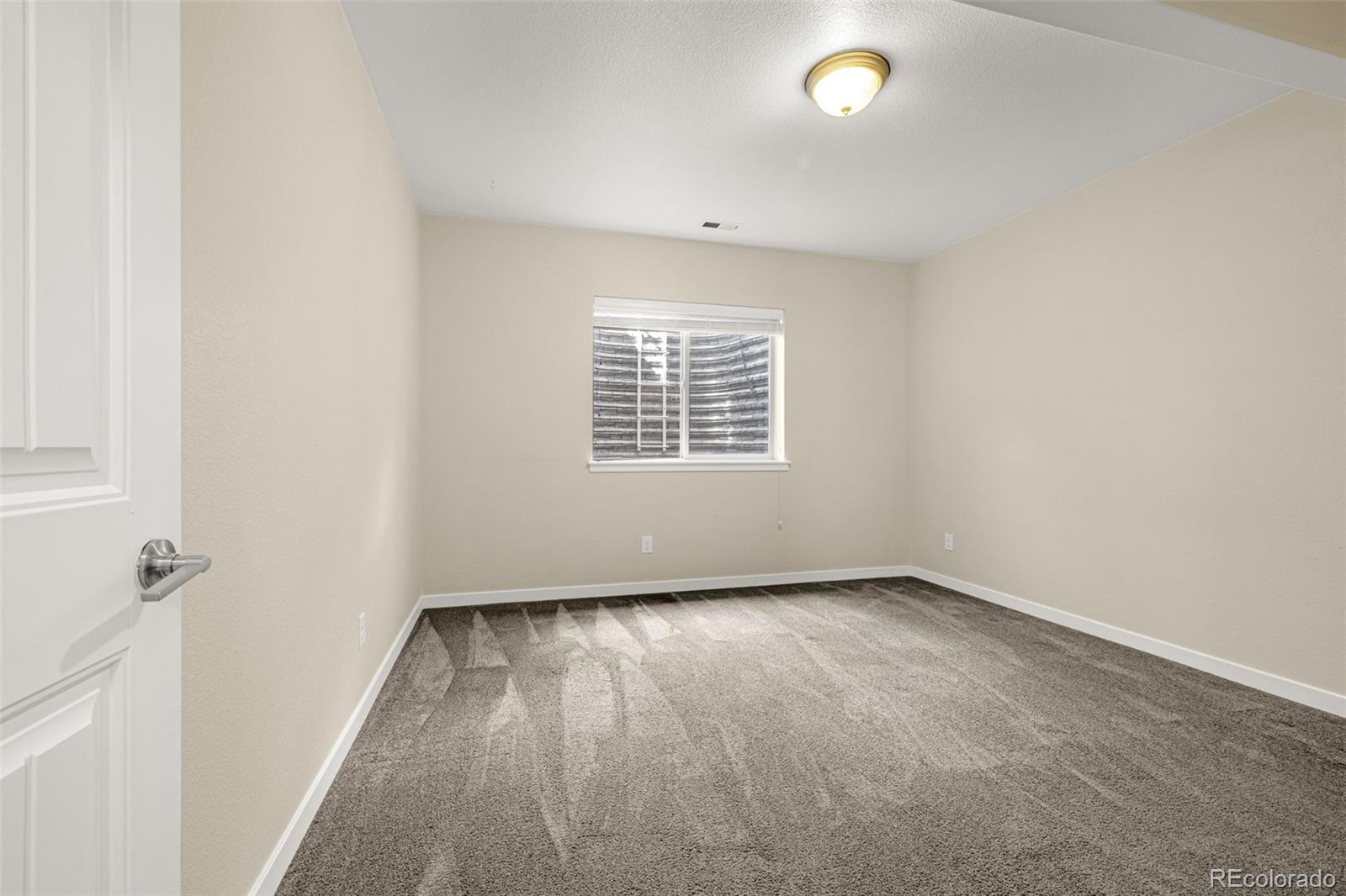 2052 Ruffino Drive Colorado Springs, CO 80921 - Photo 25 of 36 an empty room with wooden floor and windows