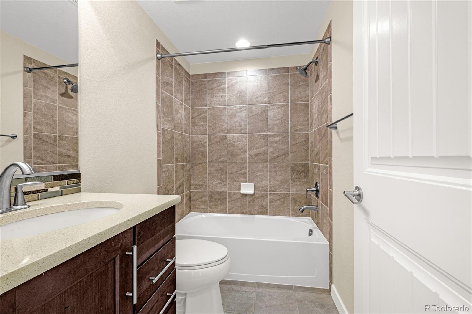 2052 Ruffino Drive Colorado Springs, CO 80921 - Photo 29 of 36 a bathroom with a sink a toilet a mirror and a bathtub