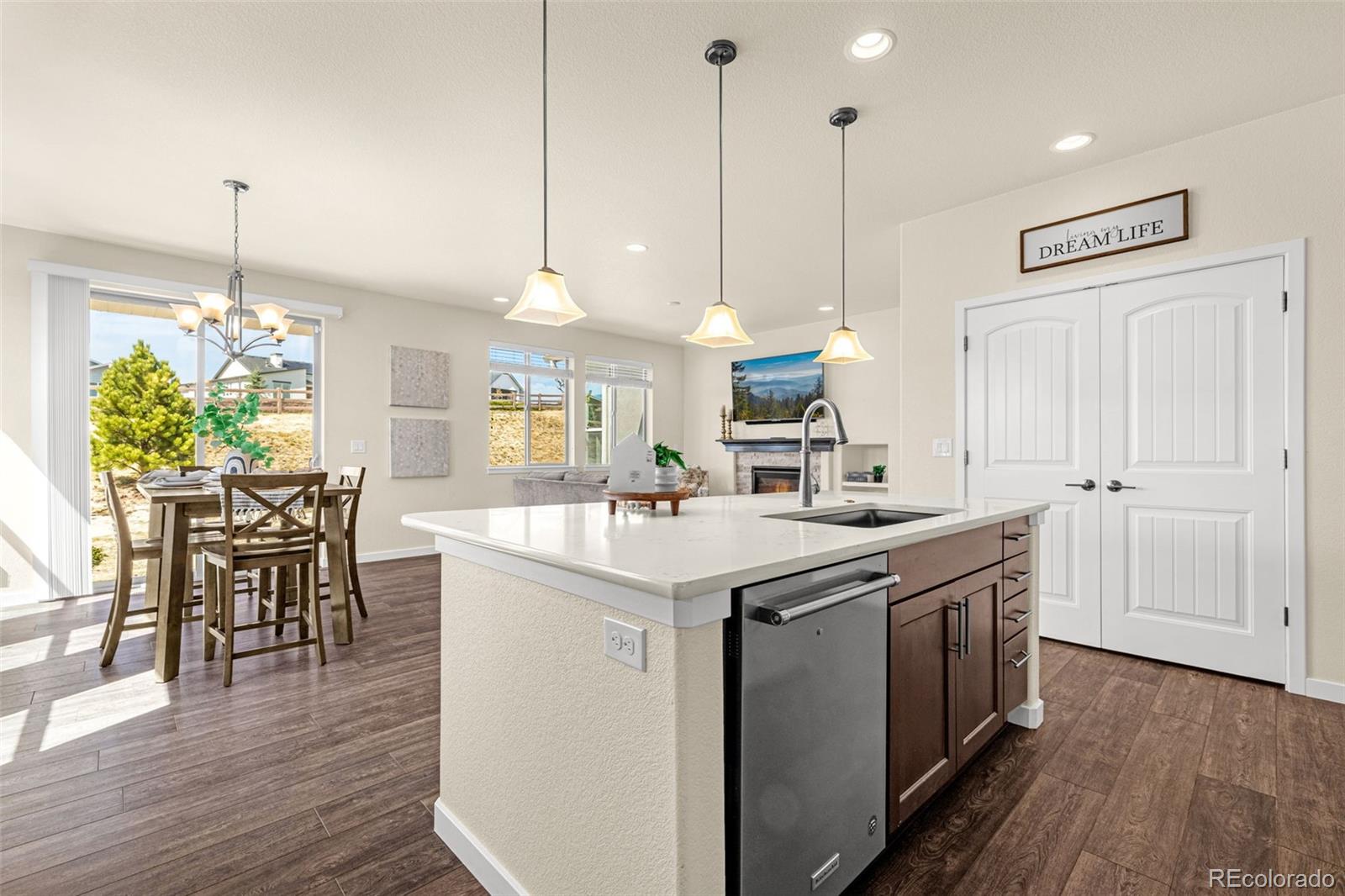 2052 Ruffino Drive Colorado Springs, CO 80921 - Photo 6 of 36 a kitchen with kitchen island a sink a stove a dining table and chairs