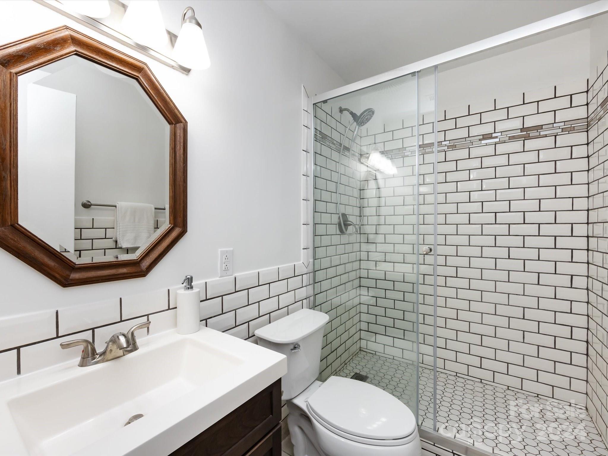 430 Queens Road, Unit 112 Charlotte, NC 28207 - Photo 12 of 19 a bathroom with a sink a toilet and shower