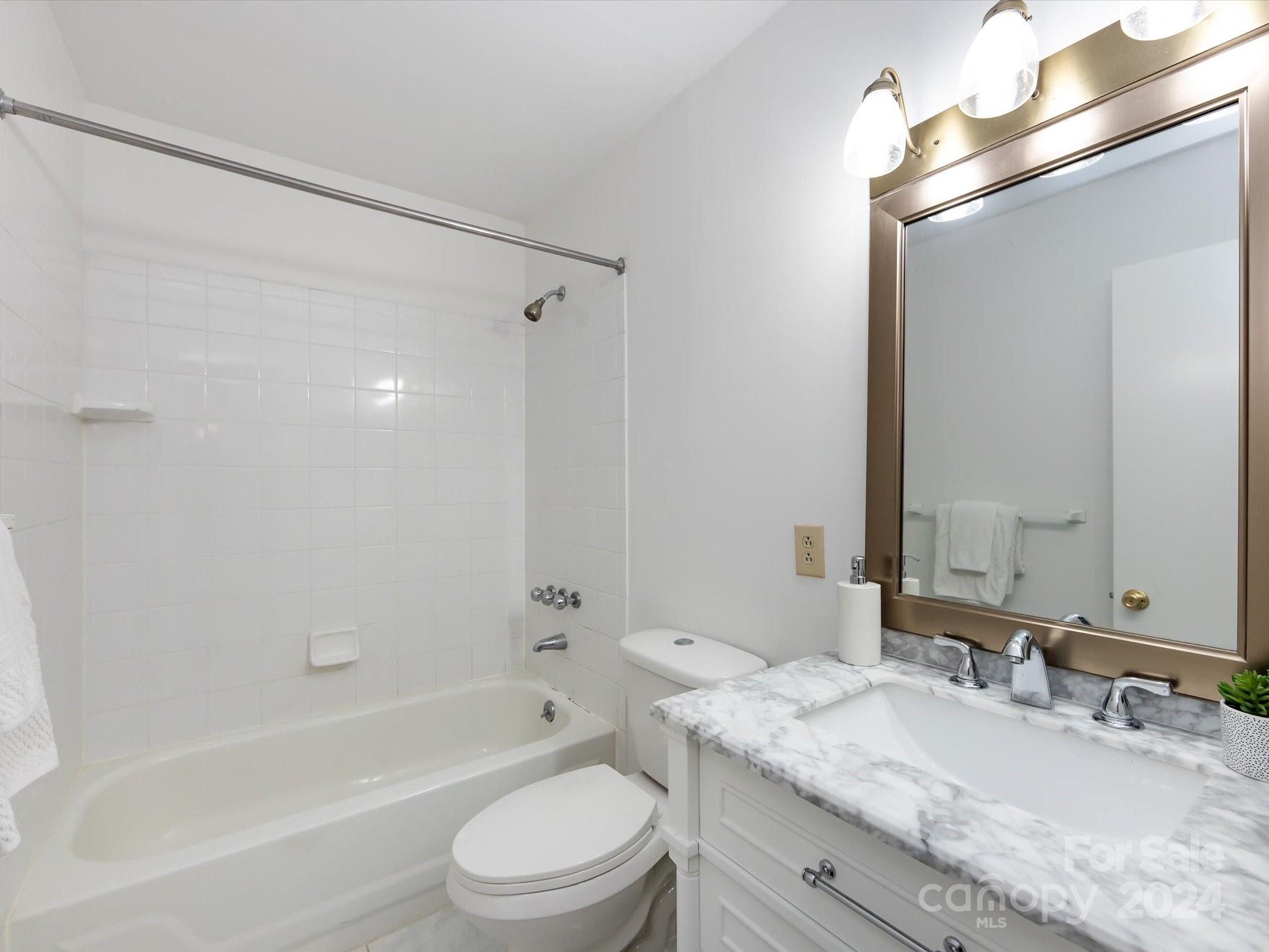 430 Queens Road, Unit 112 Charlotte, NC 28207 - Photo 15 of 19 a bathroom with a granite countertop sink a toilet and shower