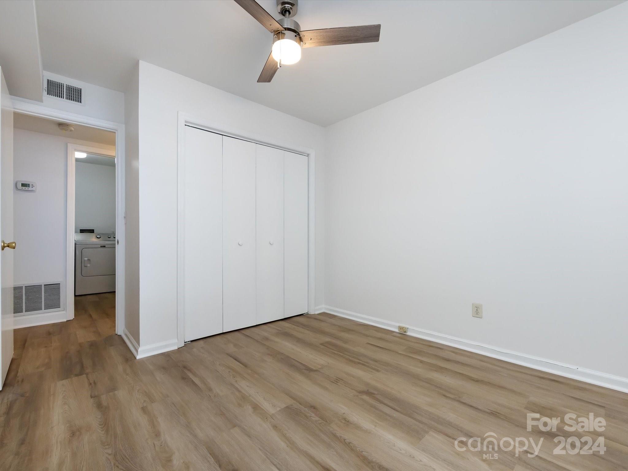 430 Queens Road, Unit 112 Charlotte, NC 28207 - Photo 16 of 19 an empty room with wooden floor and windows