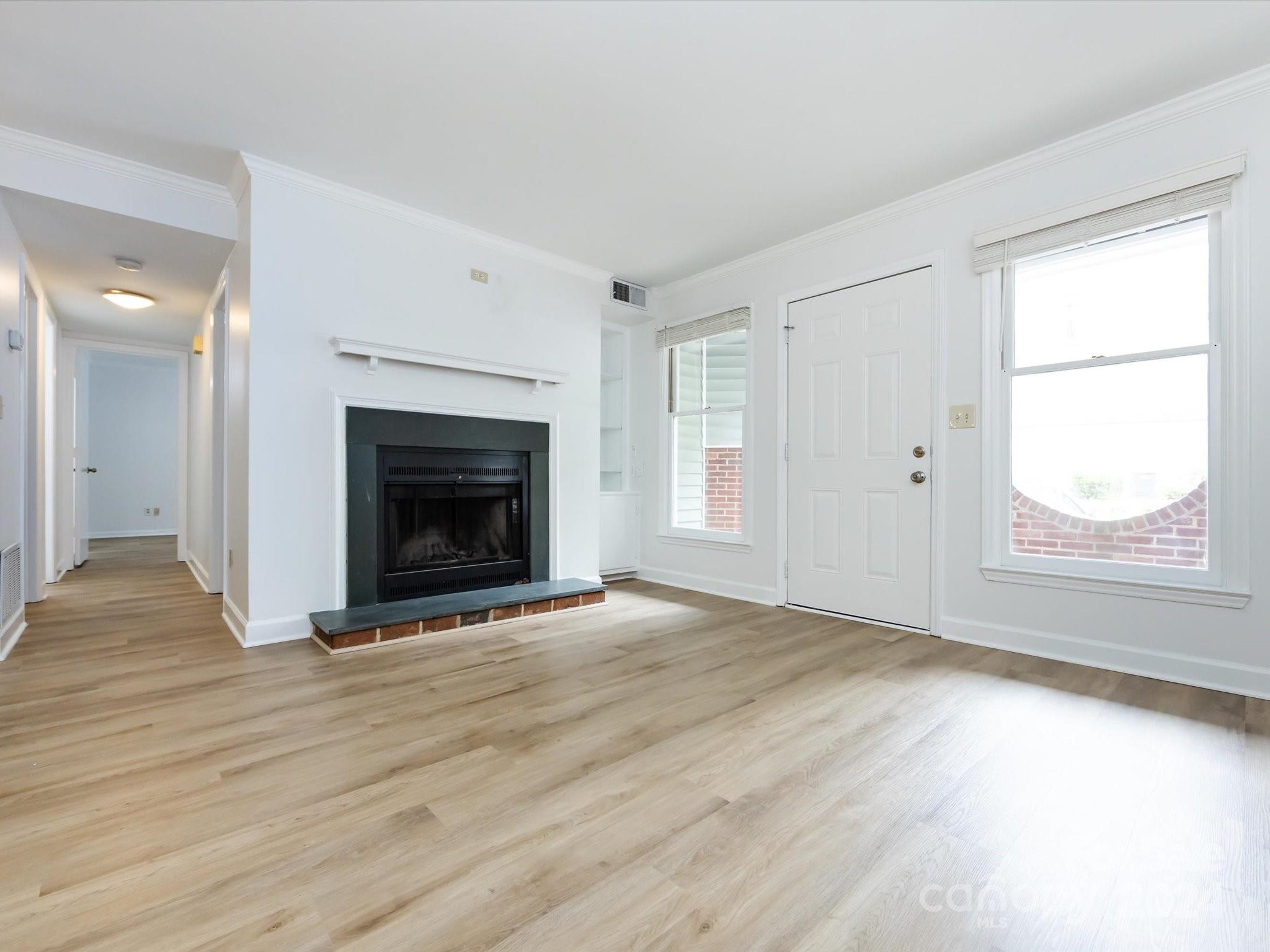 430 Queens Road, Unit 112 Charlotte, NC 28207 - Photo 5 of 19 an empty room with windows and fireplace