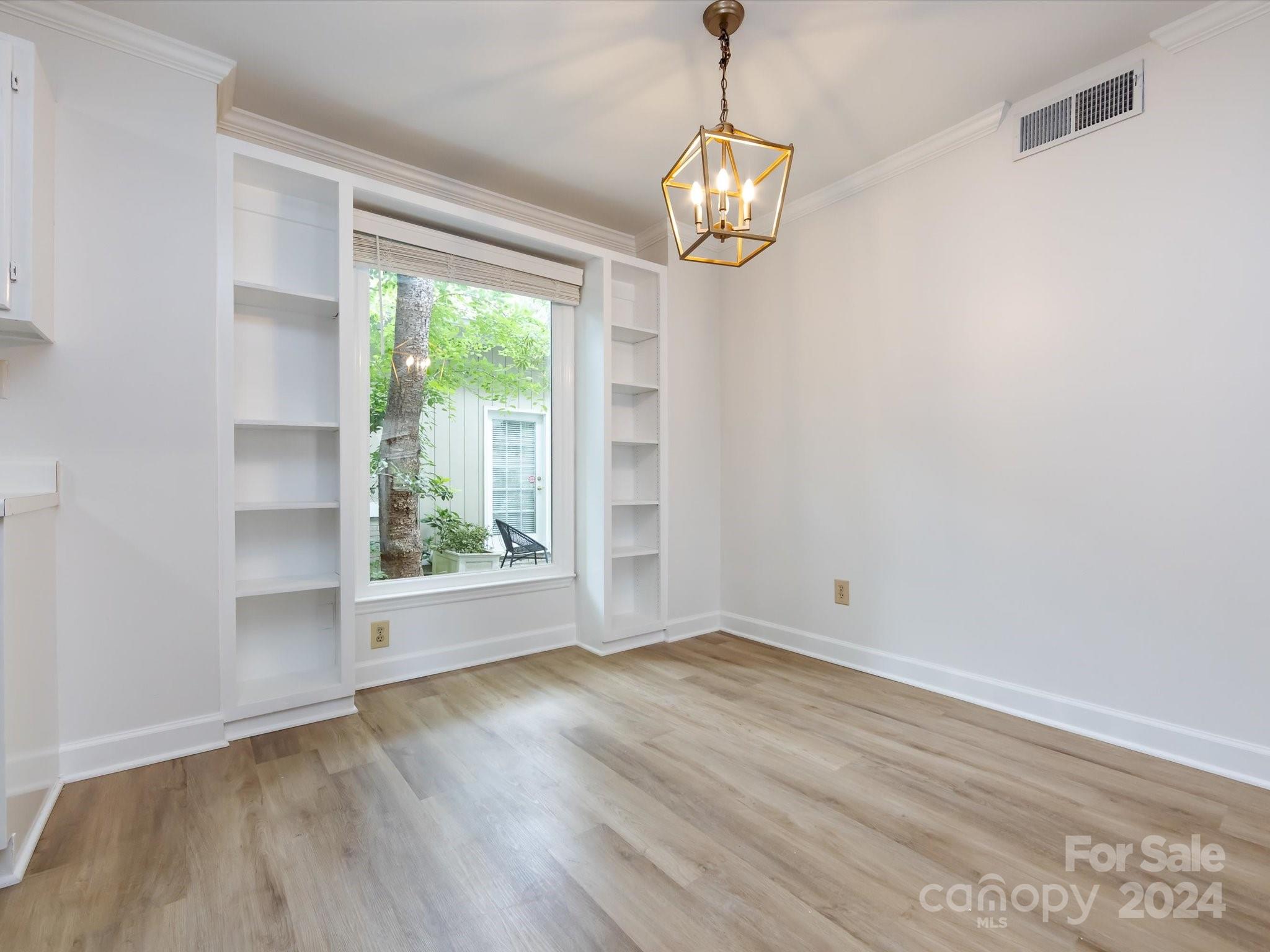 430 Queens Road, Unit 112 Charlotte, NC 28207 - Photo 8 of 19 an empty room with wooden floor and windows