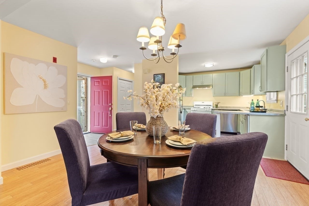 29d S Commons, Unit D Lincoln, MA 01773 - Photo 13 of 36 a view of a dining room with furniture a chandelier and wooden floor