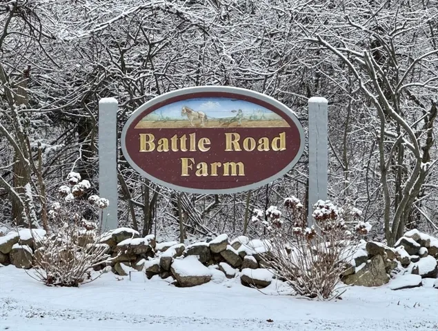 a view of a white house next to a road and yard