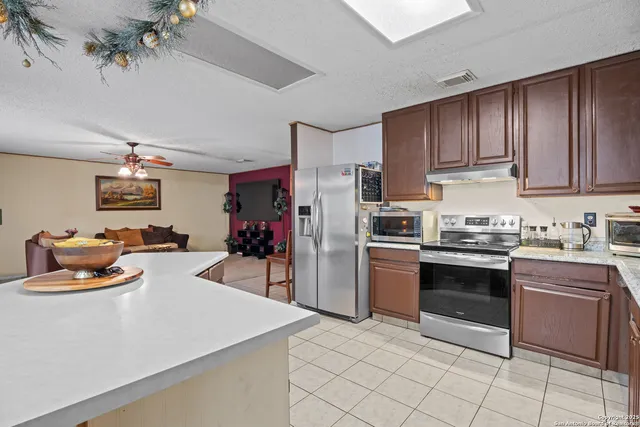 a kitchen with stainless steel appliances granite countertop a sink dishwasher stove top oven and cabinets