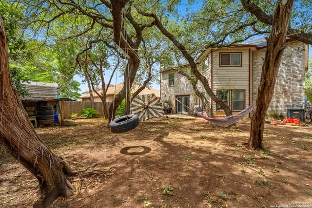 a view of a yard with wooden fence and a tree