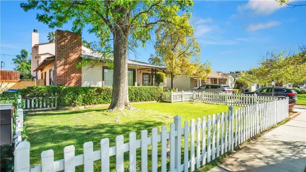 a view of an house with backyard and a tree