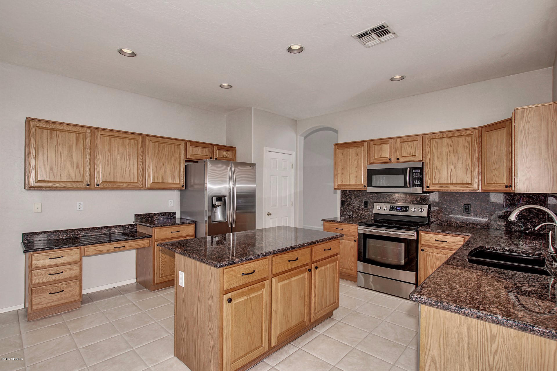 1360 East Harrison Street Gilbert, AZ 85295 - Photo 7 of 34 a kitchen with stainless steel appliances granite countertop a stove top oven a sink dishwasher a refrigerator and white cabinets with wooden floor