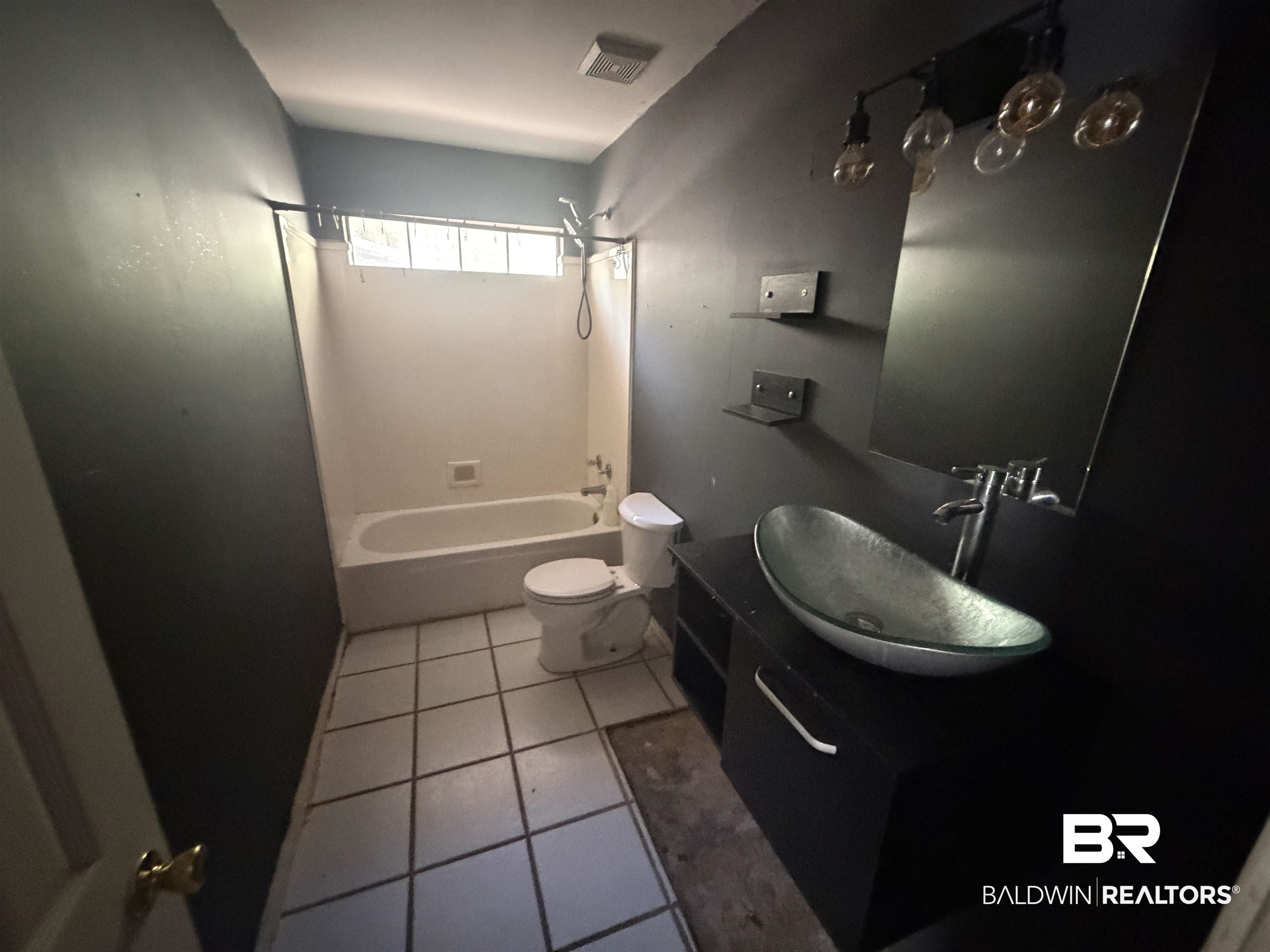 7067 Pinehill Road Daphne, AL 36526 - Photo 14 of 18 Bathroom featuring vanity, light tile patterned floors, and washtub / shower combination