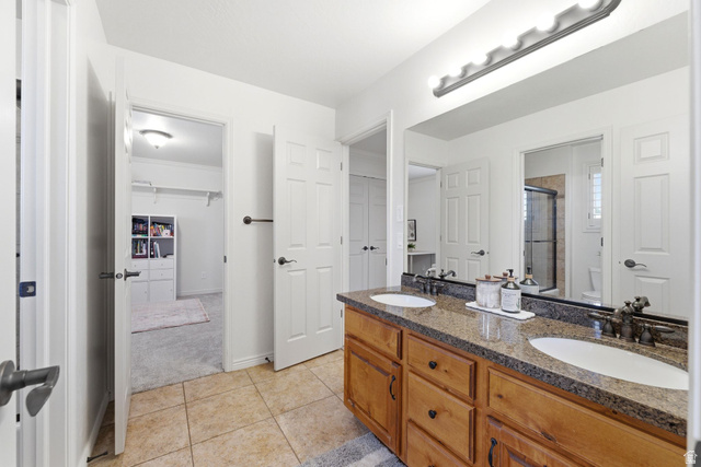 1712 Somerset Ridge Drive Draper, UT 84020 - Photo 41 of 76 Bathroom featuring a double vanity with wood cabinetry, a granite-look countertop, and dual oval undermount sinks