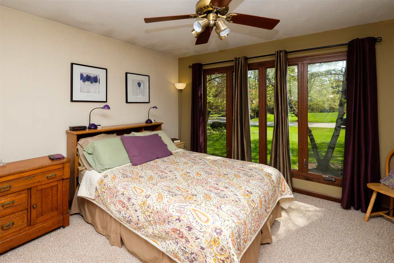 8211 Clockview Road Rockford, IL 61108 - Photo 11 of 25 a bedroom with a large bed and a chandelier