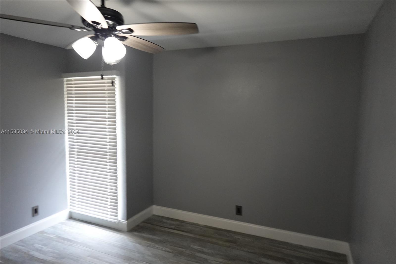 Townhouses at Jacaranda Condominiums Plantation, FL 33324 - Photo 24 of 50 an empty room with wooden floor fan and windows