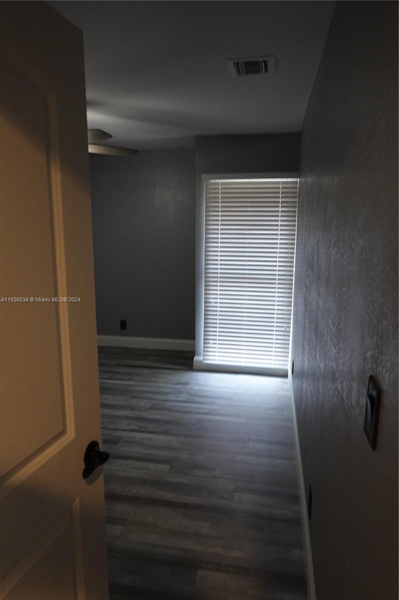 Townhouses at Jacaranda Condominiums Plantation, FL 33324 - Photo 27 of 50 a view of an empty room with wooden floor and a window