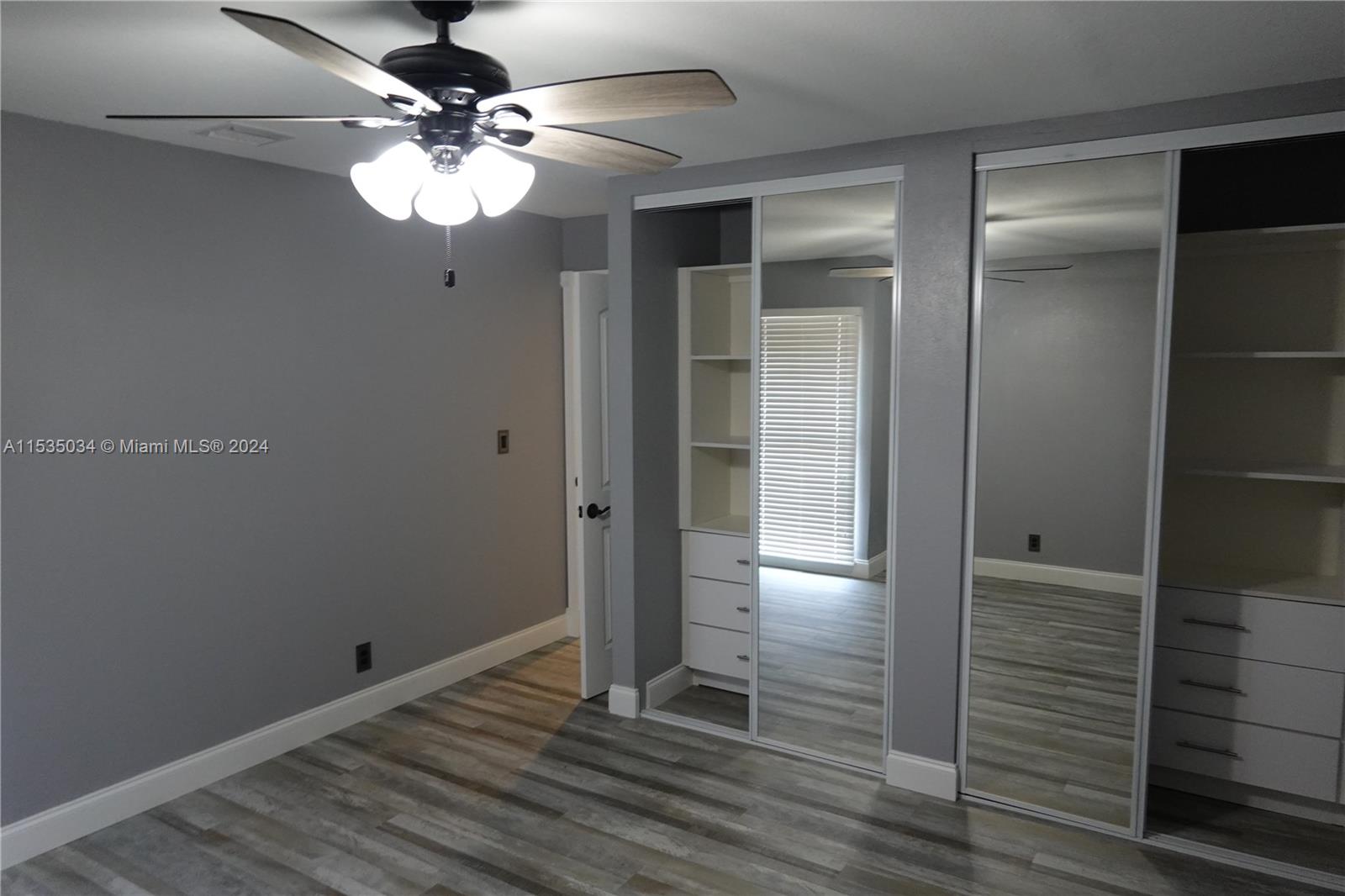 Townhouses at Jacaranda Condominiums Plantation, FL 33324 - Photo 30 of 50 an empty room with wooden floor fan and window