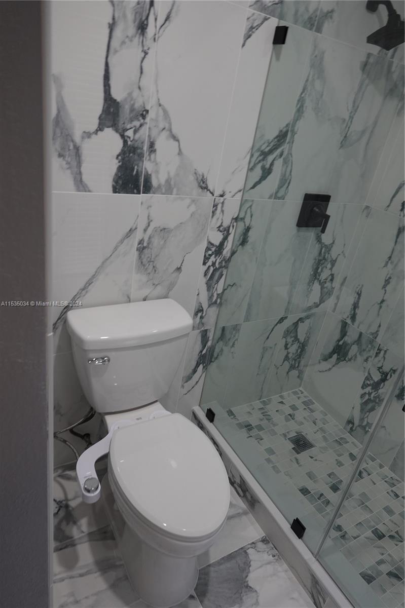 Townhouses at Jacaranda Condominiums Plantation, FL 33324 - Photo 34 of 50 a white toilet sitting next to a bath tub and a shower