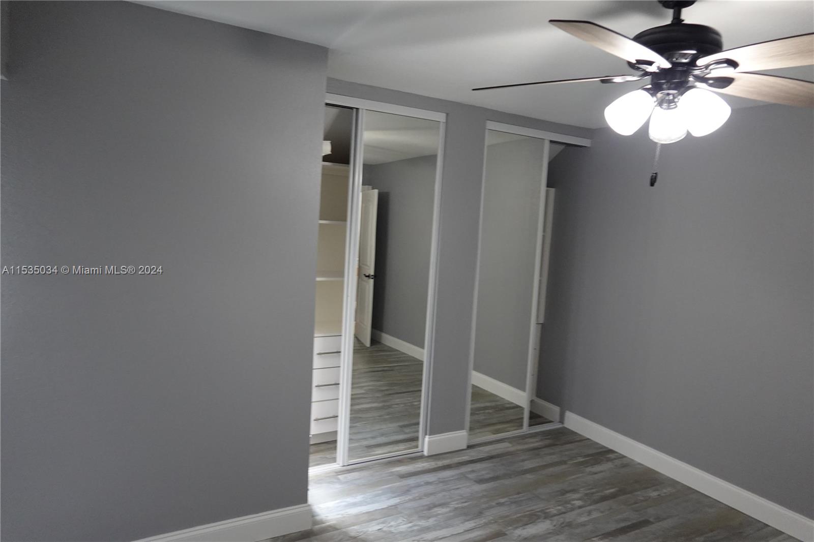 Townhouses at Jacaranda Condominiums Plantation, FL 33324 - Photo 39 of 50 an empty room with wooden floor and fan