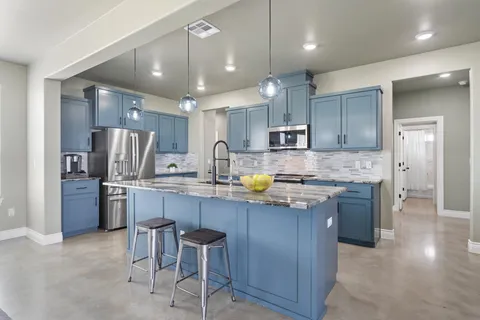 a kitchen with stainless steel appliances granite countertop a sink refrigerator and cabinets