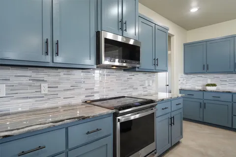 a kitchen with stainless steel appliances granite countertop a sink stove and microwave