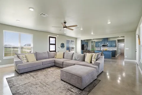 a living room with furniture and view of kitchen