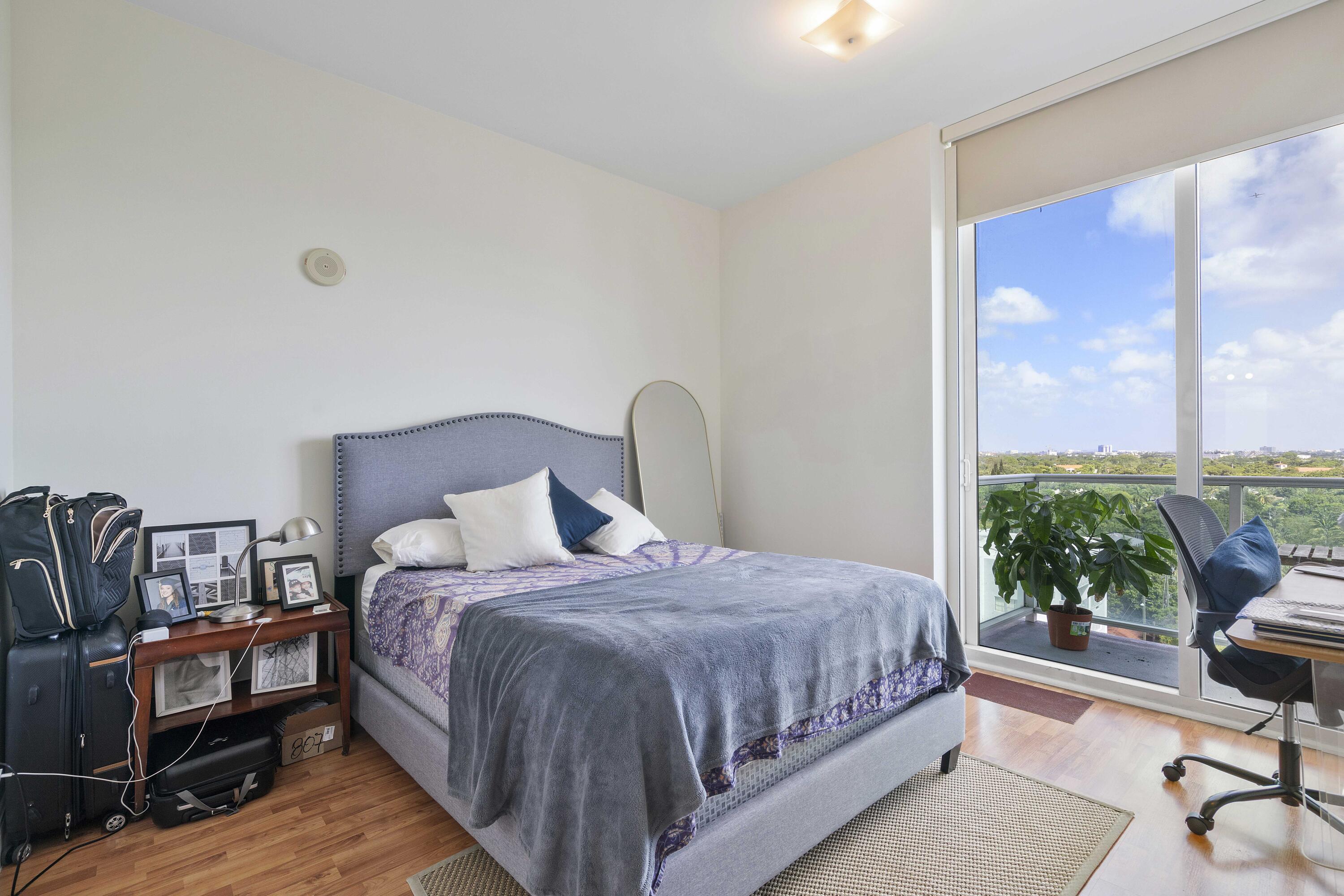 2525 Southwest 3rd Avenue, Unit 807 Miami, FL 33129 - Photo 21 of 27 a bedroom with a bed a table and a large window