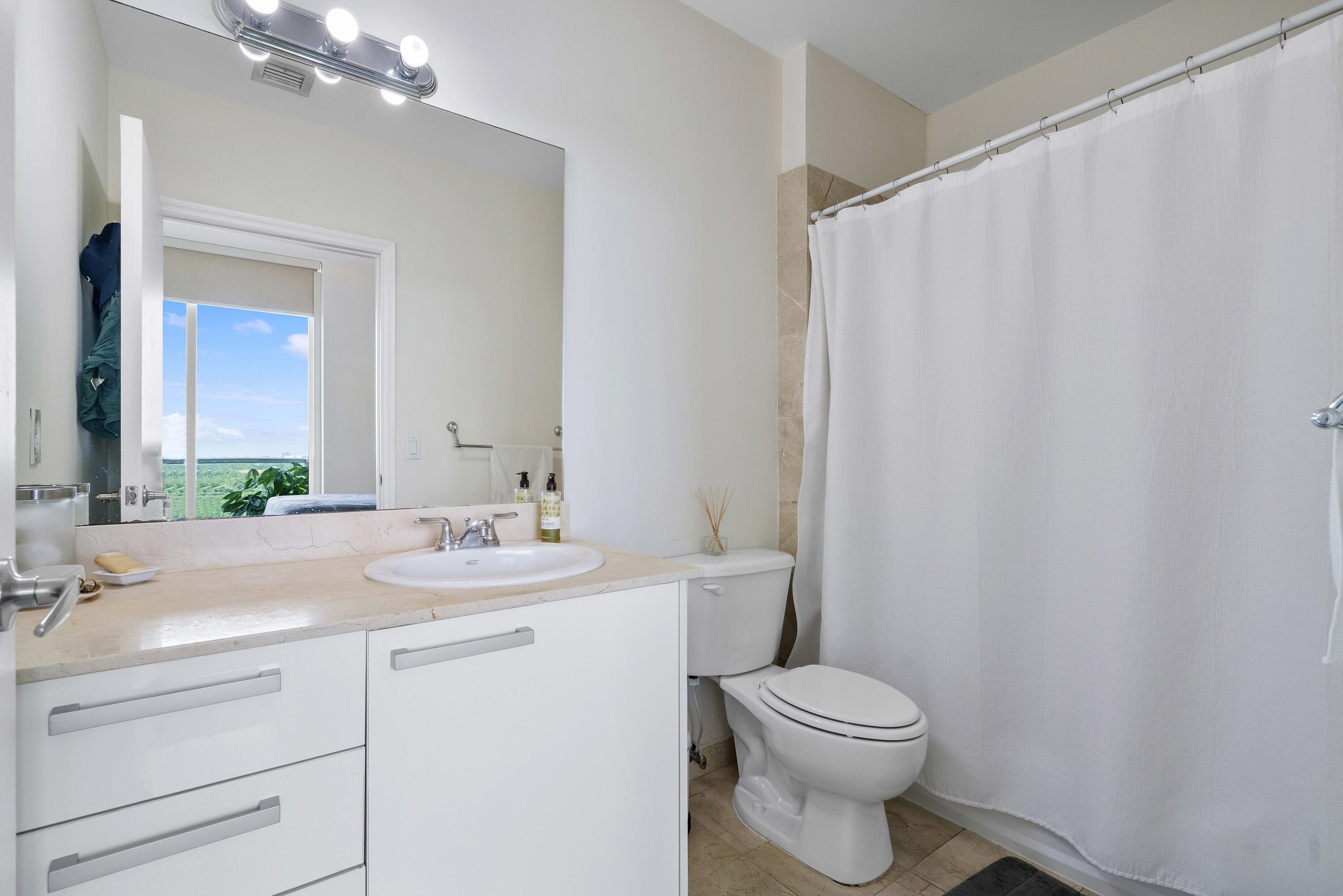 2525 Southwest 3rd Avenue, Unit 807 Miami, FL 33129 - Photo 24 of 27 a bathroom with a toilet a sink and a mirror