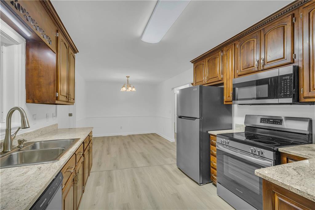 450 Stagecoach Way Danielsville, GA 30633 - Photo 30 of 65 a kitchen with stainless steel appliances granite countertop a refrigerator a stove top oven a sink and dishwasher