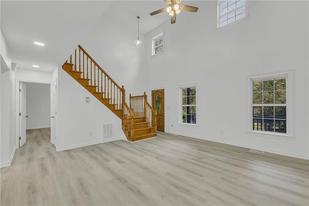 450 Stagecoach Way Danielsville, GA 30633 - Photo 4 of 65 an empty room with wooden floor chandelier and windows