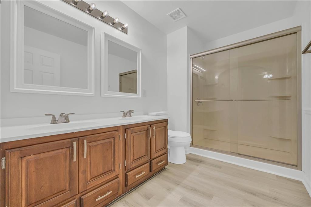 450 Stagecoach Way Danielsville, GA 30633 - Photo 45 of 65 a bathroom with a double vanity sink and mirror