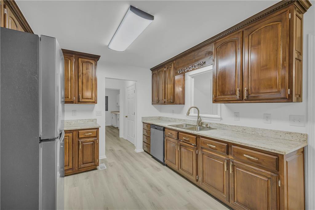 450 Stagecoach Way Danielsville, GA 30633 - Photo 5 of 65 a kitchen with stainless steel appliances granite countertop wooden cabinets a sink and dishwasher
