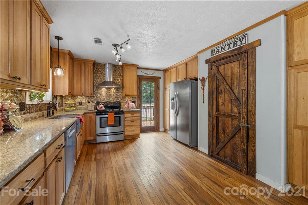 553 Sandifer Road York, SC 29745 - Photo 9 of 24 a kitchen with stainless steel appliances granite countertop a refrigerator a stove and a sink with wooden floors