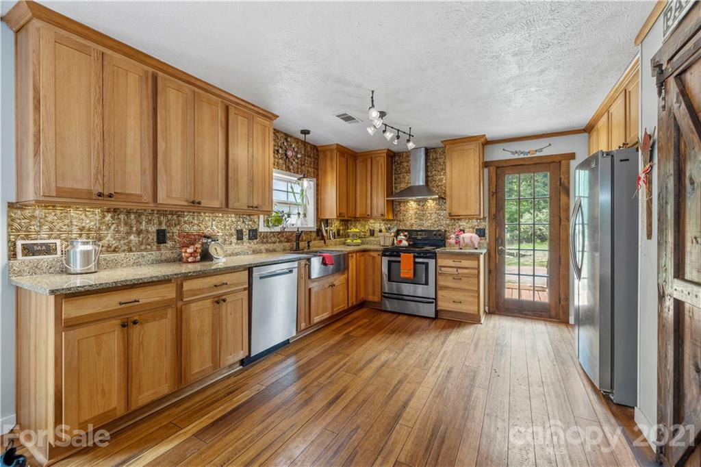 553 Sandifer Road York, SC 29745 - Photo 10 of 24 a kitchen with stainless steel appliances granite countertop wooden floors a stove and a refrigerator