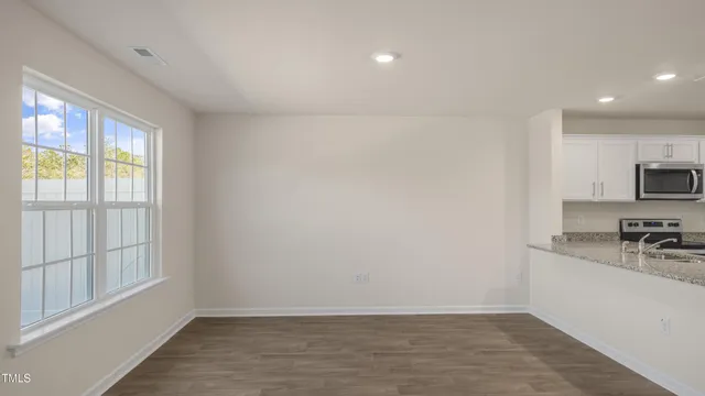 a view of a kitchen with wooden floor and electronic appliances