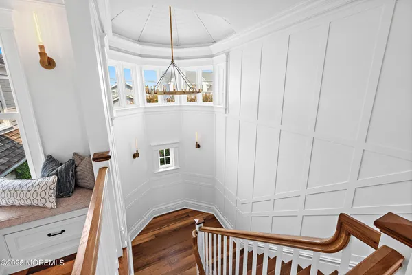 a view of a hallway with wooden floor and staircase