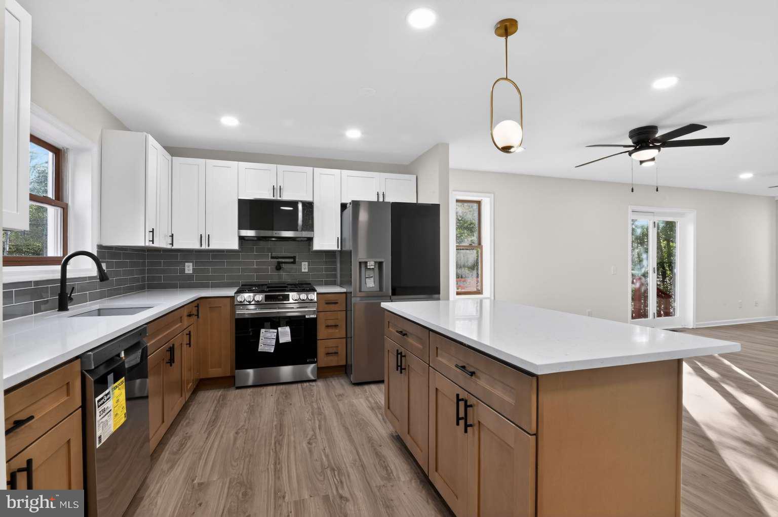 271 Academy Road Woodbine, NJ 08270 - Photo 22 of 37 a kitchen with stainless steel appliances a sink dishwasher a refrigerator a kitchen island with wooden cabinets and floor