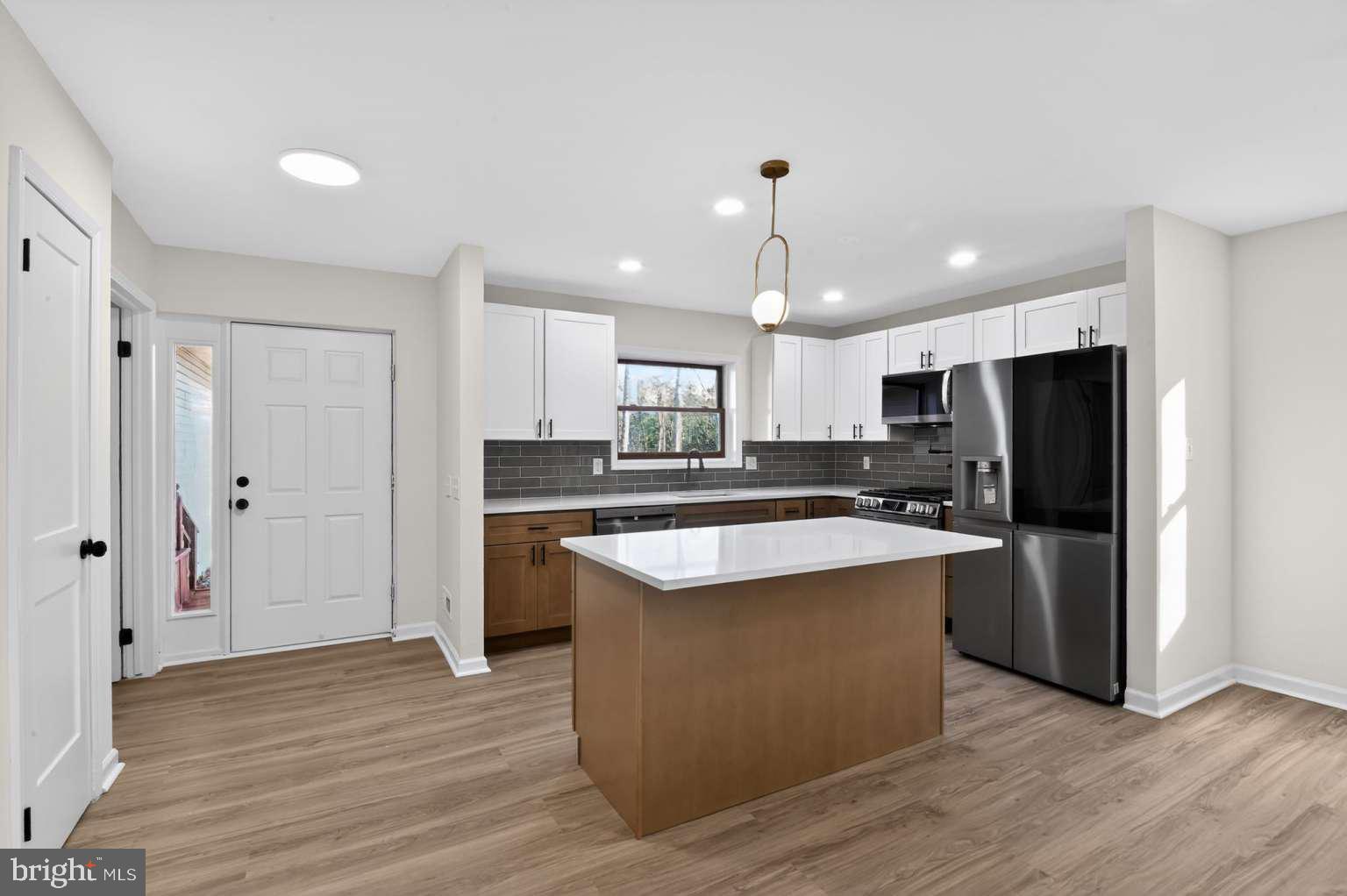 271 Academy Road Woodbine, NJ 08270 - Photo 24 of 37 a kitchen with kitchen island a sink wooden floor and refrigerator