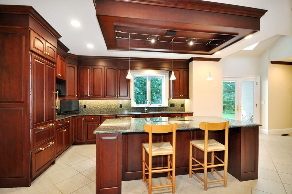 103 Revolutionary Road Concord, MA 01742 - Photo 13 of 39 a kitchen with stainless steel appliances granite countertop table chairs sink and cabinets